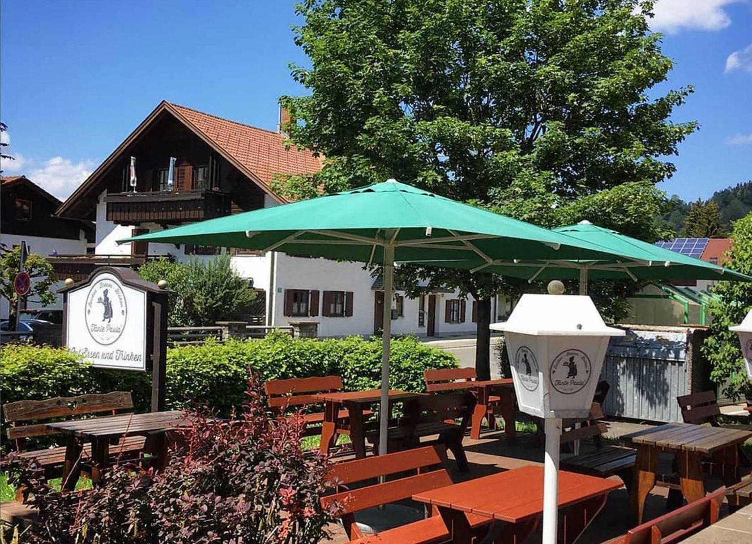 Tante Paula in Burgberg von außen, an einem schönen Sommertag mit Blick auf den Biergarten und großem Sonnenschirm.