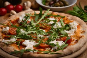 Knusprige Pizza mit Rucola, Büffelmozzarella, Kirschtomaten und italienischen Gewürzen, serviert auf einem Holzbrett, mit Oliven und Pilzen im Hintergrund.